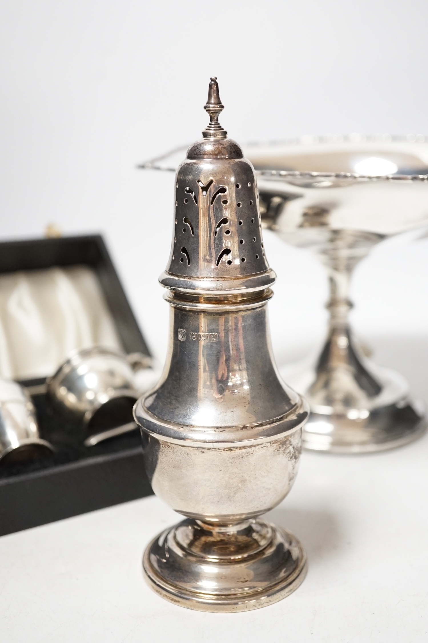 A modern silver baluster sugar caster, Birmingham, 1972, 17.5cm, a cased silver three piece condiment set an a George V silver tazza, weighted.